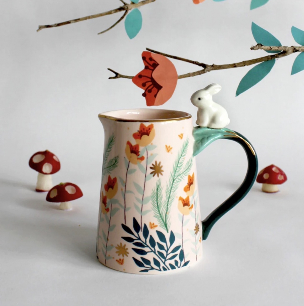 Materialer:  Porselen

Egenskaper:  En dekorativ melkekanne med en supersøt keramisk kanin plassert på håndtaket. Den er ferdig med et nydelig bladmønster på toppen av en myk rosa glasur. Den har gulldetaljer for å legge til litt luksus. Det ville være en