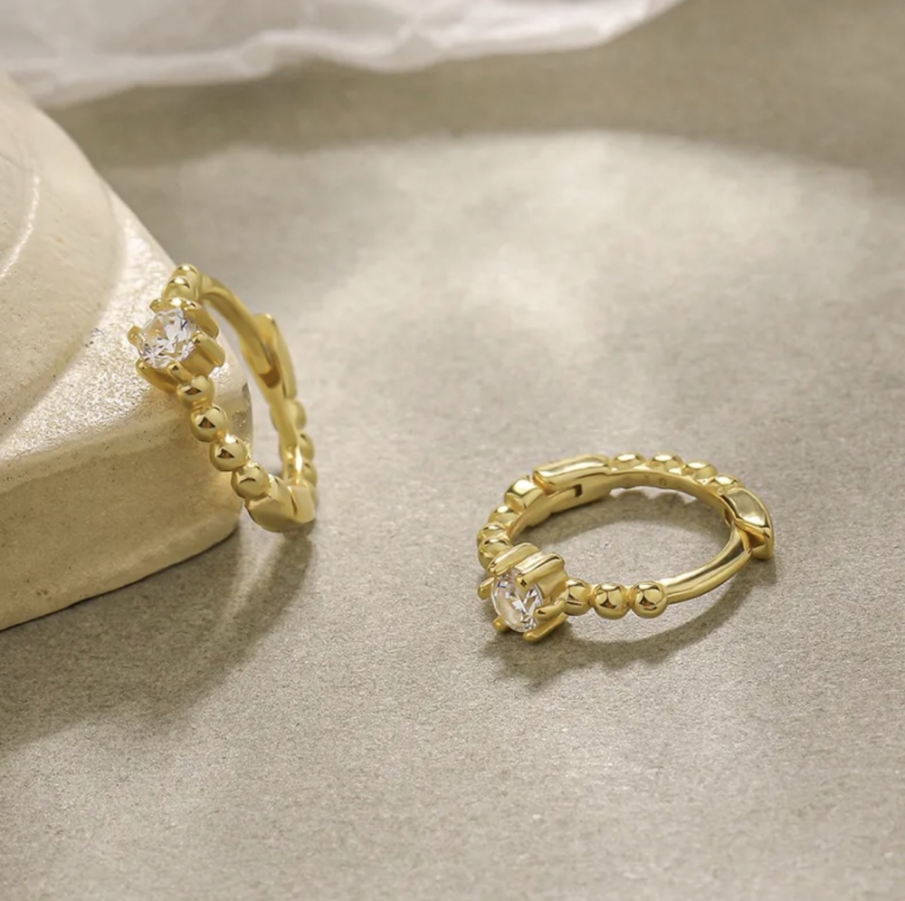 Nydelige øredobber fra Ella & Pia. Smykkene er laget av 925 Stearling Silver som er belagt med 18K gull med zirikoniastener. Øreringene måler 10,5mm og veier 1g. Smykkene er nikkel- og blyfrie, og allergivennlige.