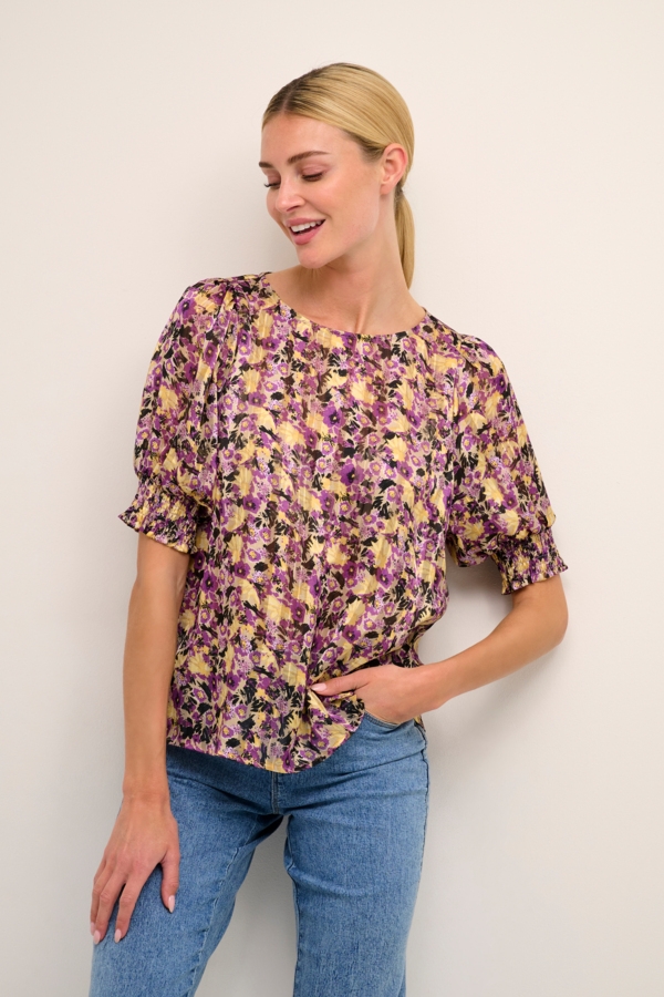 Lett og tynn bluse i med et fint mønster i gult og lilla. Blusen er rett i fasongen og er laget av polyester. 
